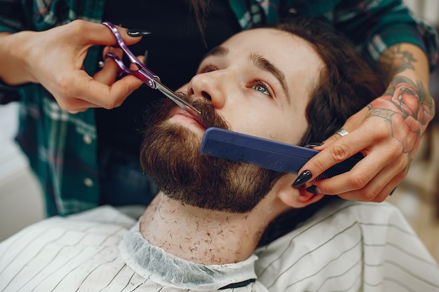 Elegante uomo seduto in un negozio di barbiere