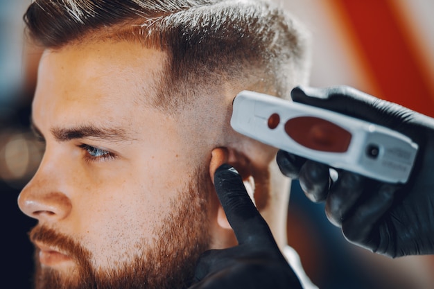Бесплатное фото Стильный мужчина сидит в парикмахерской