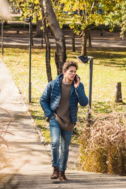 Stylish man talking on mobile phone outdoors