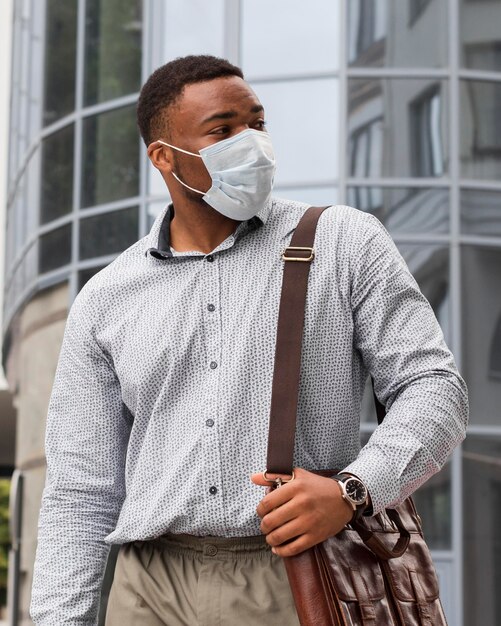 Stylish man with face mask on his way to work during pandemic