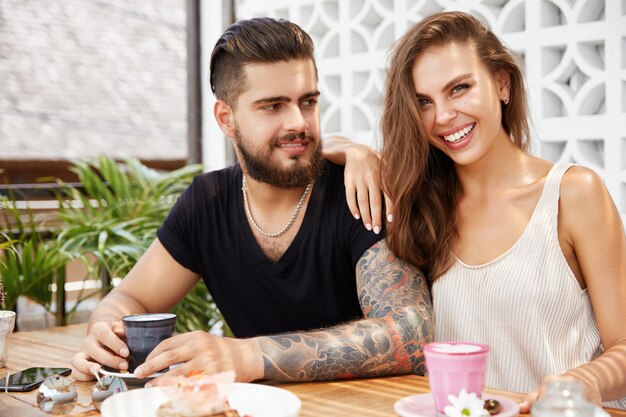 Stylish man and woman sitting in cafe