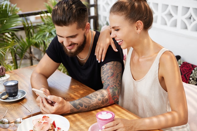 Stylish man and woman sitting in cafe