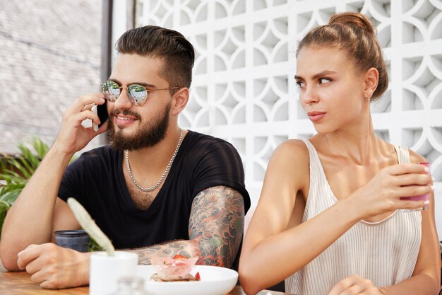 Stylish man and woman sitting in cafe