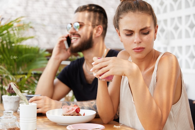 Free photo stylish man and woman sitting in cafe