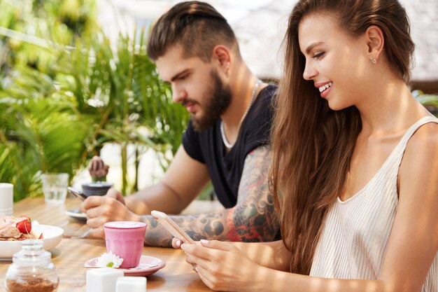 Stylish man and woman sitting in cafe