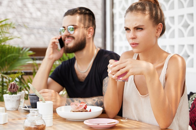 Stylish man and woman sitting in cafe