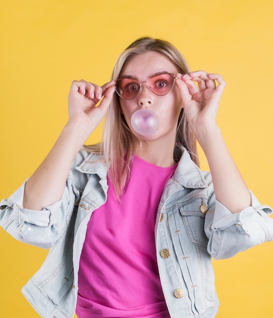 Free photo stylish model blowing bubble gum