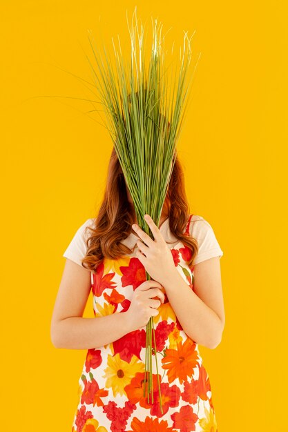 Free photo stylish model holding plants front view