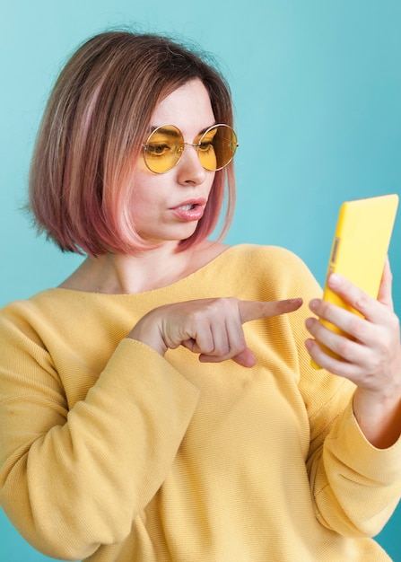 Stylish model pointing at phone