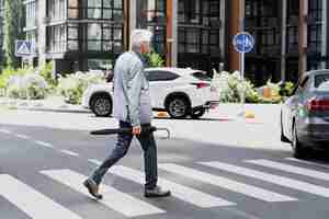 無料写真 傘をさしながら通りを横切る都会のおしゃれな老人