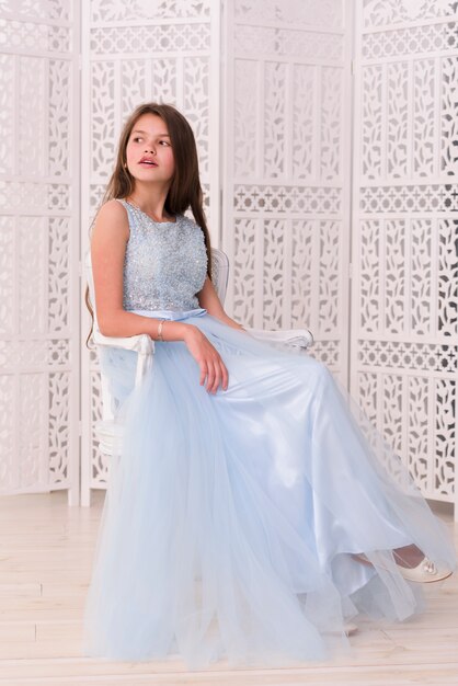 Stylish pretty girl sitting on chair at home