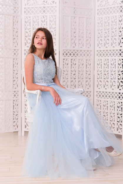 Stylish pretty girl sitting on chair at home