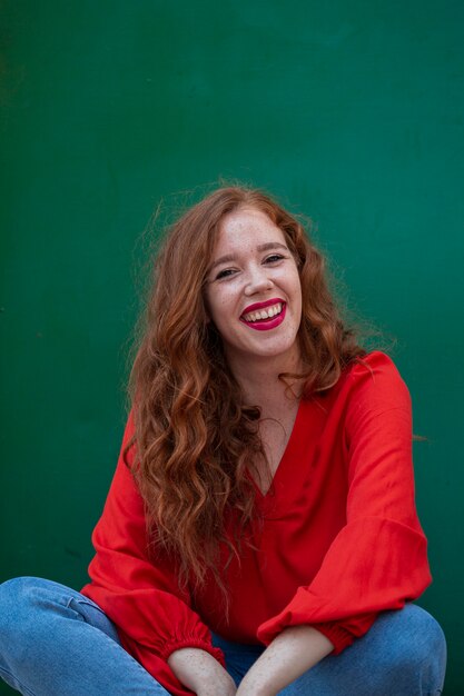 Stylish redhead woman posing  with green background