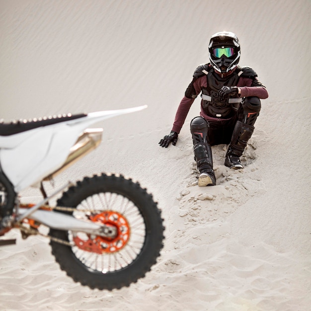 Stylish rider with motorbike in the desert