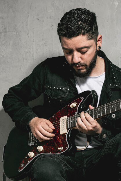 stylish rocker playing vintage guitar