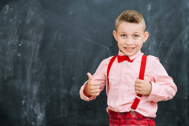 Foto gratuita elegante scolaro gestire i pollici in su