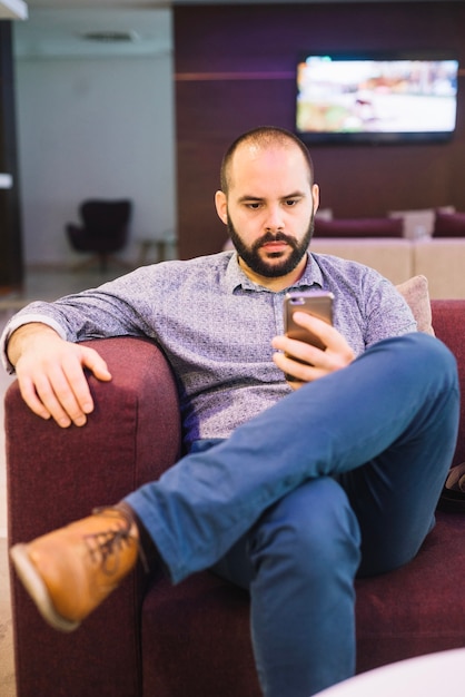 Free photo stylish serious man with phone at home