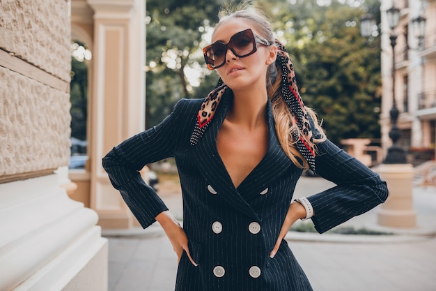 Free photo stylish sexy woman dressed in elegant tuxedo suit walking in city on summer spring day