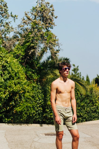 무료 사진 안경 야외에서 포즈와 세련된 shirtless 젊은 남자
