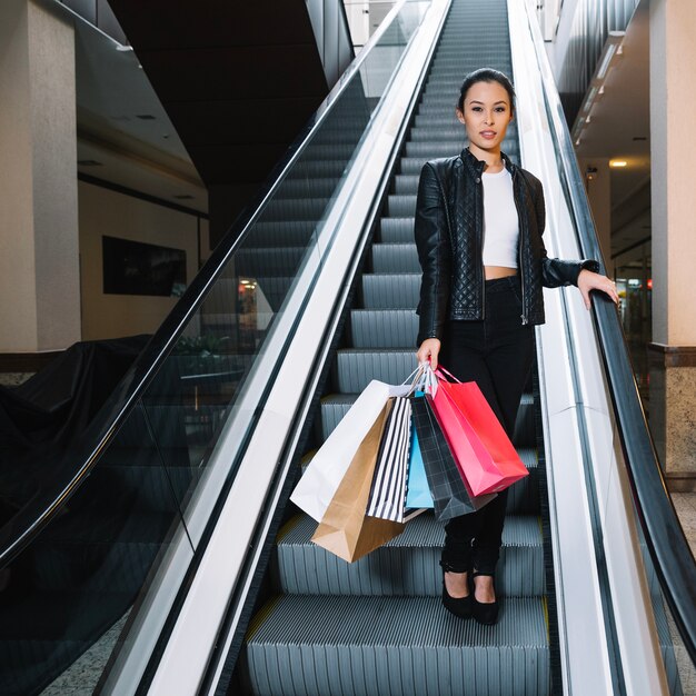 Stylish shopper posing on escalator