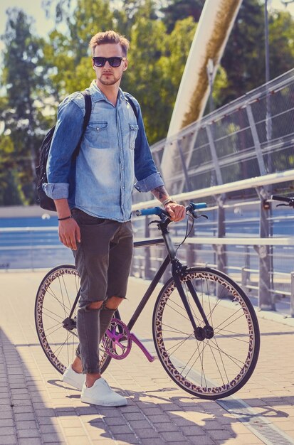 Stylish single speed cyclist on a bridge.