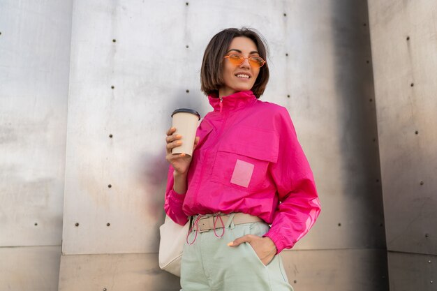 Stylish sportive woman with short hairstyle posing with coffee cup