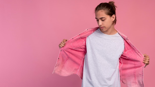 Free photo stylish teen boy in pink posing with copy space