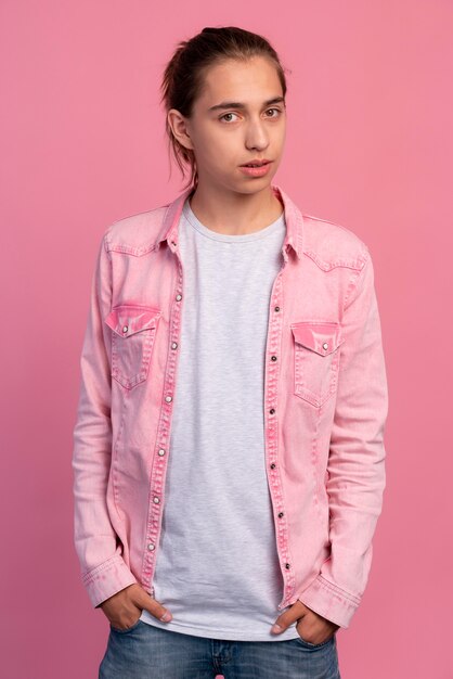 Стильный мальчик-подросток в розовом позирует