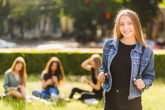 Free photo stylish teenager standing near friends