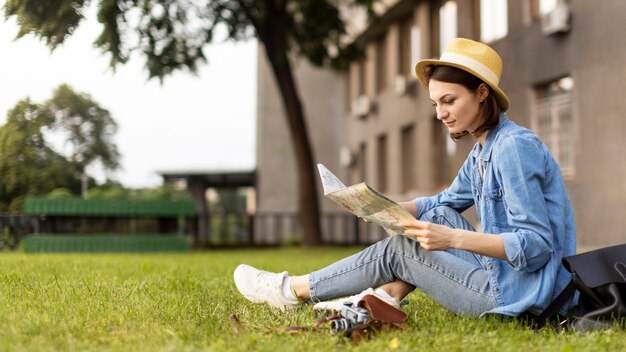 Stylish traveller with hat checking map