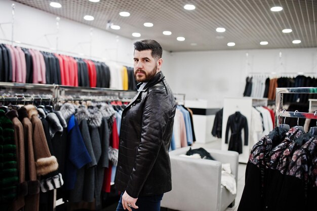 Stylish turkish man at the store of fur coats and leather jackets Successful arabian beard man