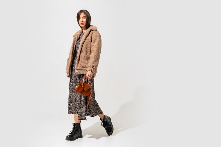Free Photo stylish woman in beige fur coat and dress posing. full length.