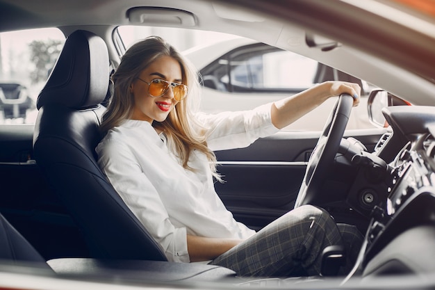 Donna alla moda in un salone di auto