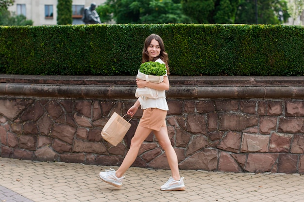 食料品の袋を運ぶスタイリッシュな女性