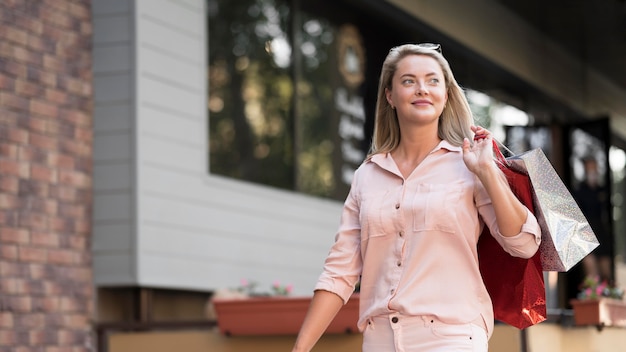 Free photo stylish woman carrying shopping bags