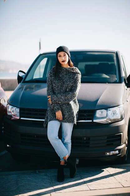 Stylish woman in front of car