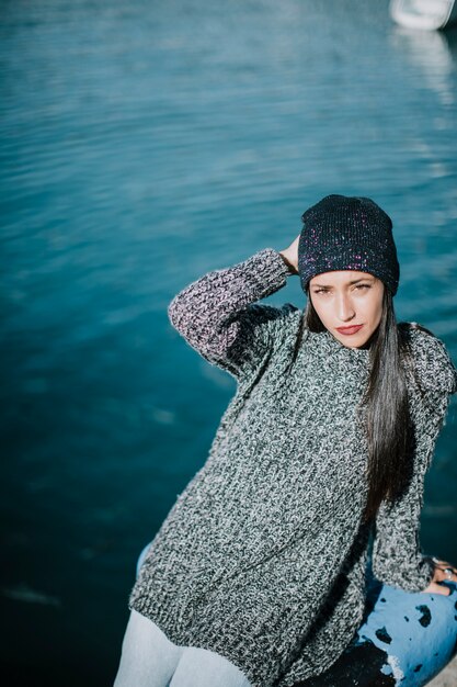 Stylish woman in front of water