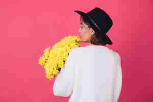 Free photo stylish woman in hat and casual white sweater on pink red wall