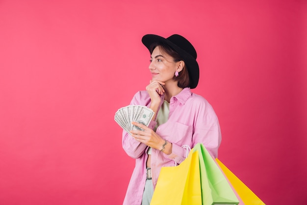 Stylish woman in hat on pink red wall