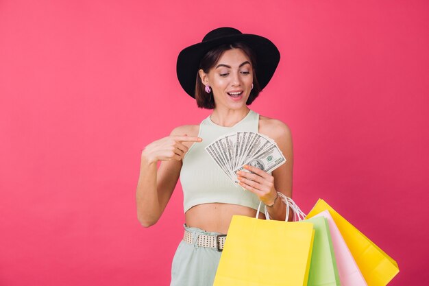 Stylish woman in hat on pink red wall