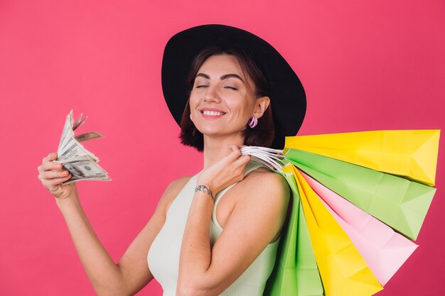 Stylish woman in hat on pink red wall