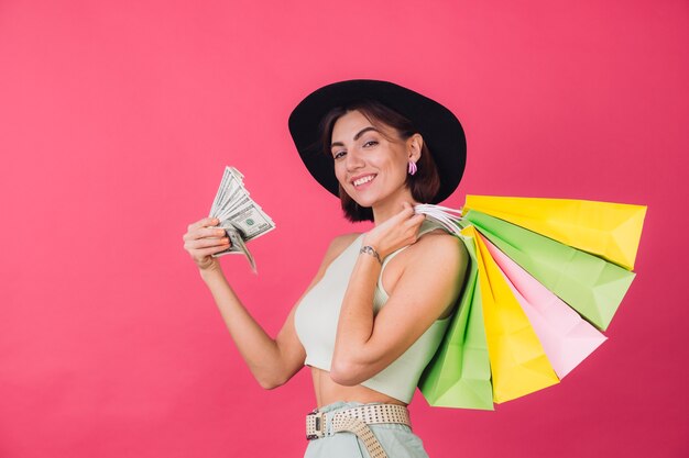 Stylish woman in hat on pink red wall