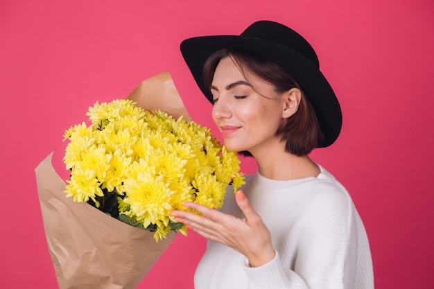 Free photo stylish woman in hat on red wall