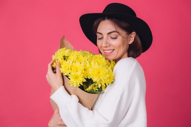 Free photo stylish woman in hat on red wall