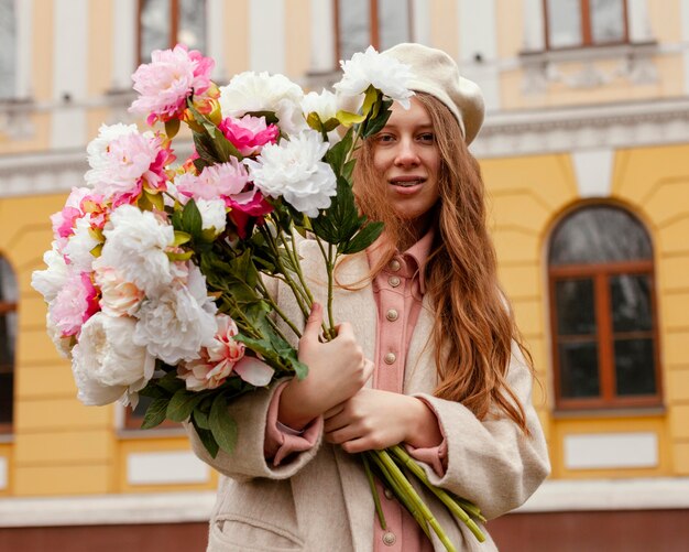 Стильная женщина, держащая букет цветов на открытом воздухе весной