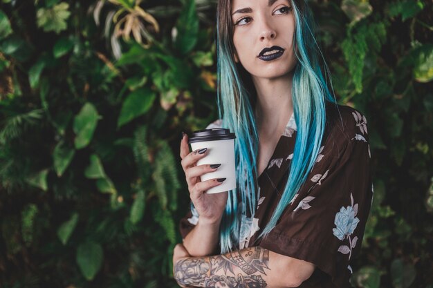 Free photo stylish woman holding disposable coffee cup