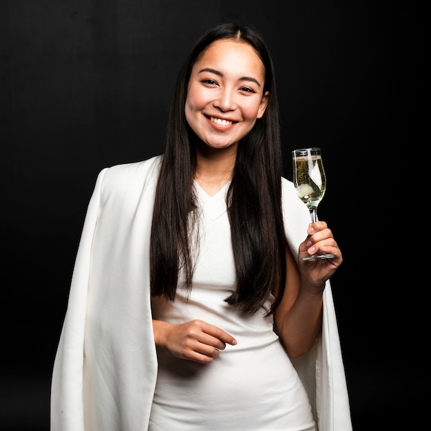 Foto gratuita donna alla moda che tiene vetro di champagne