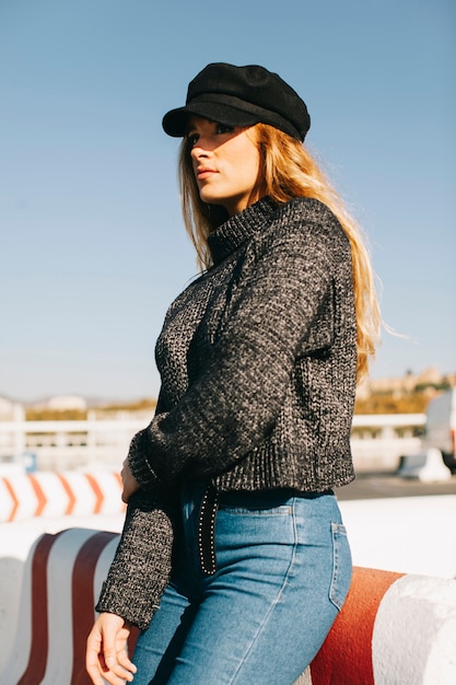 Stylish woman leaning against barrier