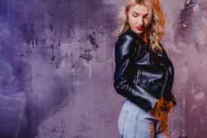 Free photo stylish woman in leather jacket at concrete wall