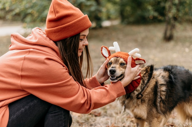 Foto gratuita donna alla moda a fare una passeggiata con il suo cane